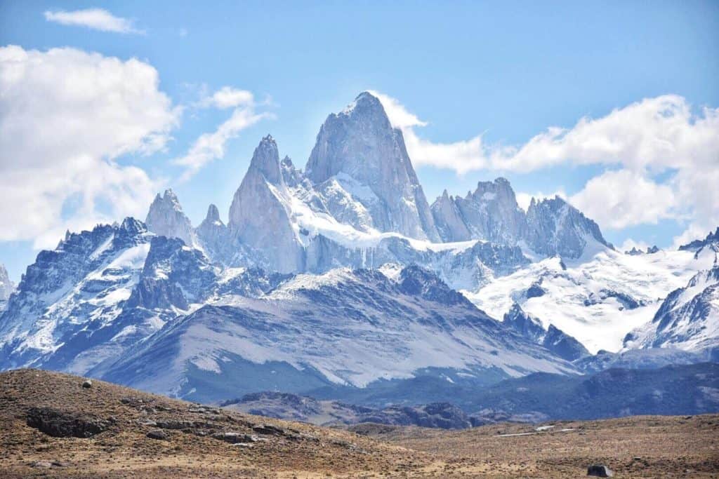 A tall mountain with snow under a blue sky.