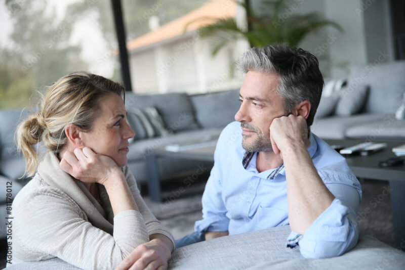 Mature couple talking to each other in sofa